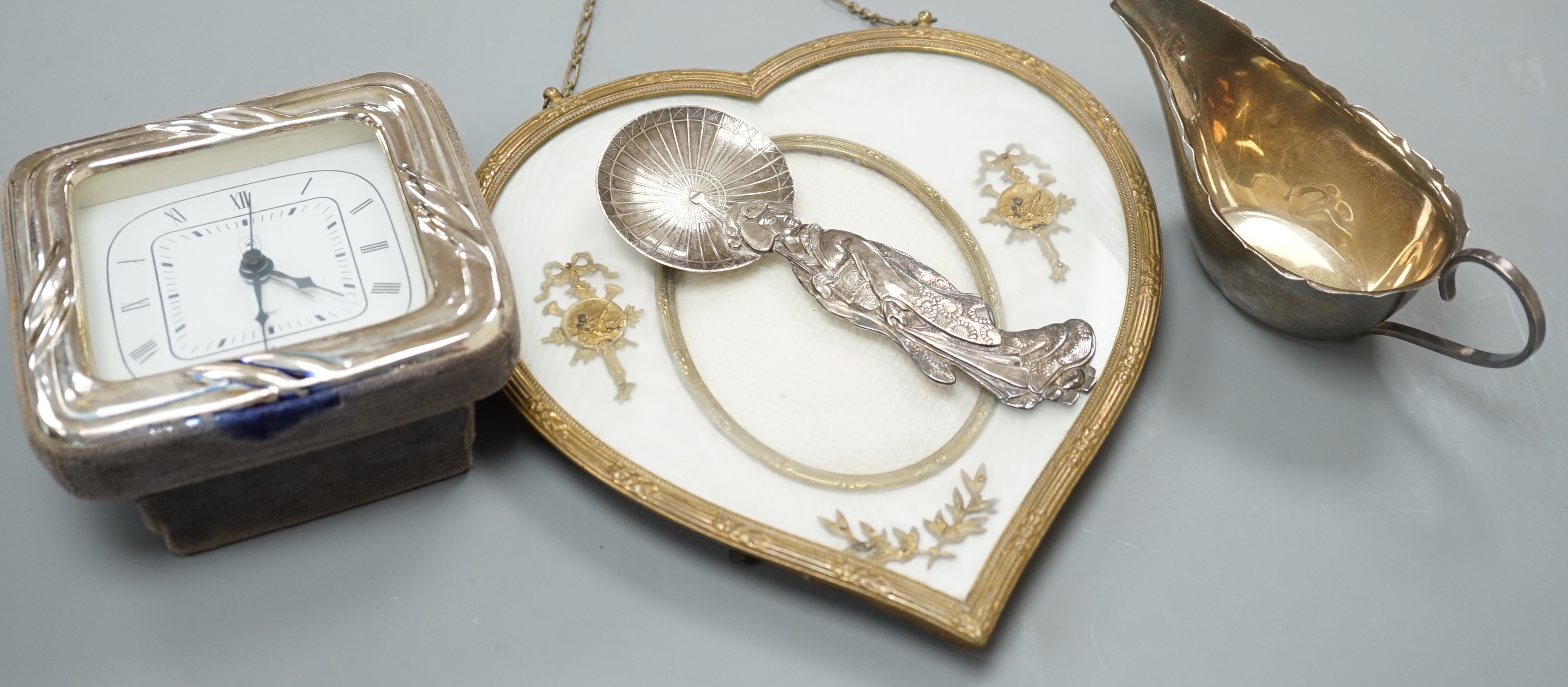 A 19th century gilt heart-shaped frame, A Japanese sterling figural spoon, a 1930's silver cream jug and modern silver mounted clock, photo frame 20 cms high.